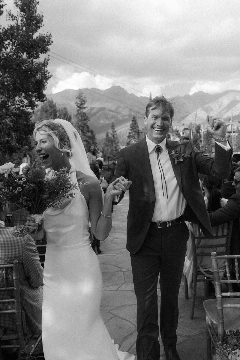 Bride and groom walking down the aisle celebrating being married