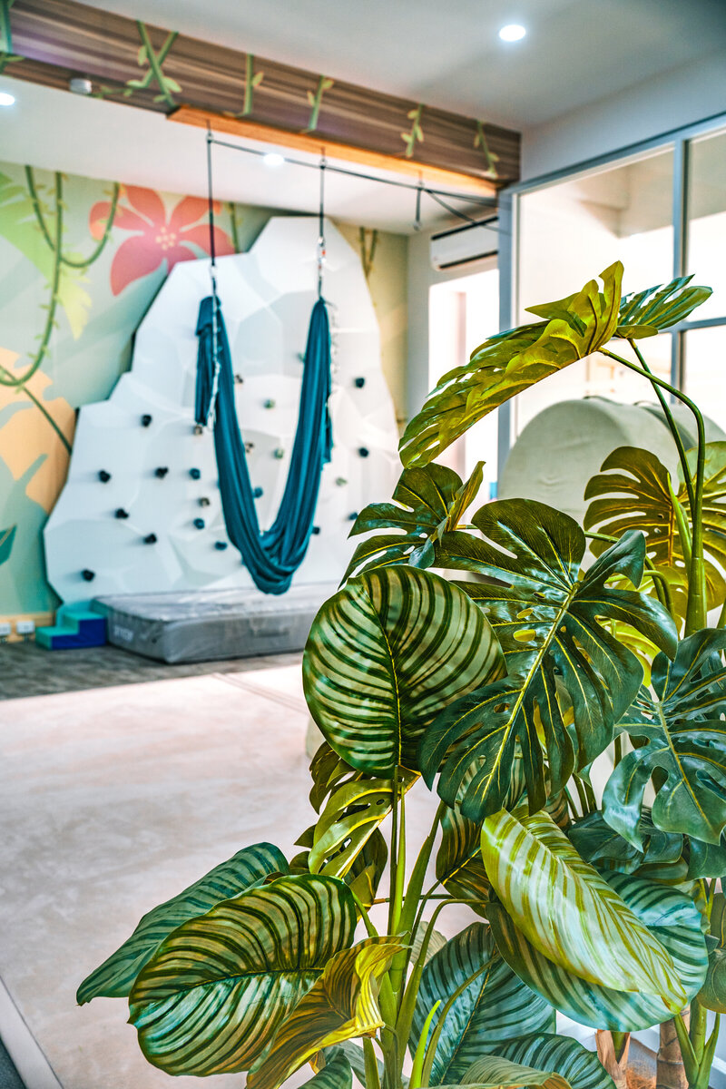 Therapy room at Deni SPOT with sensory swing and playful jungle-themed design.