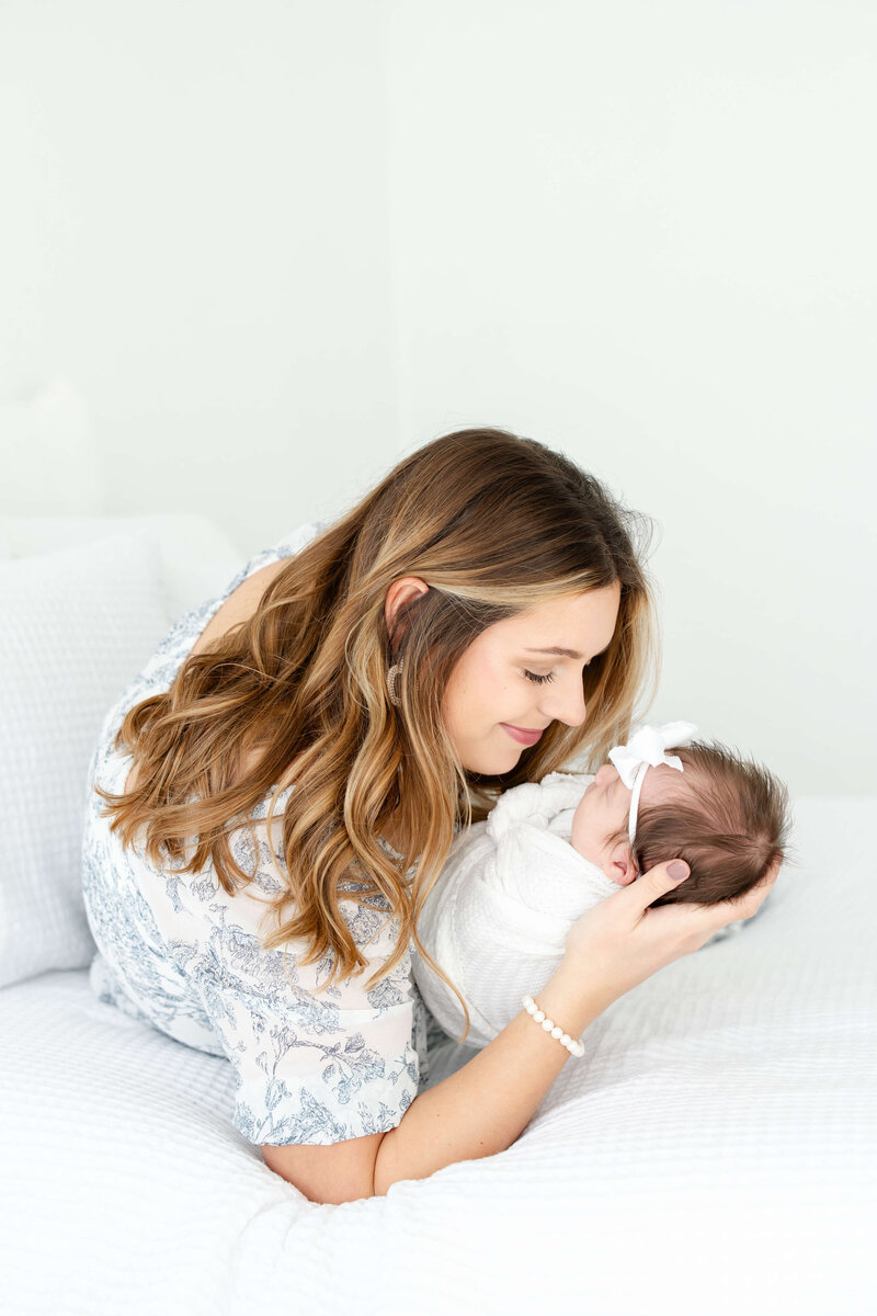 Mom holding newborn smiling