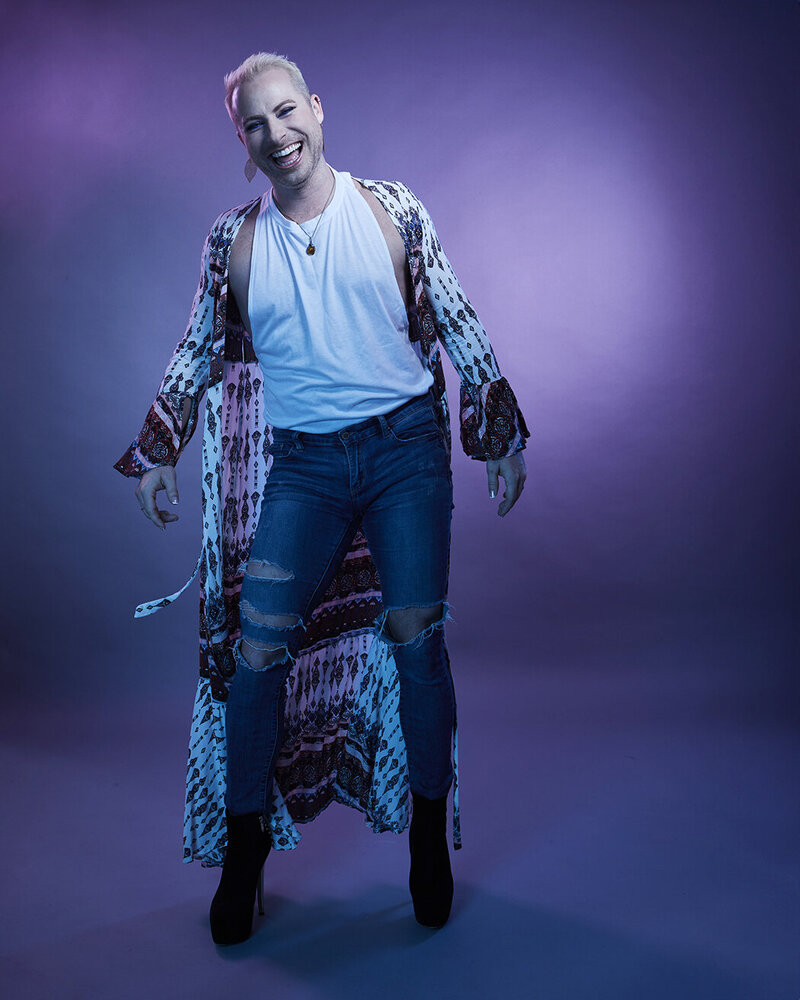 Artistic full-body portrait of Dain August in a glittering blue outfit, showcasing an expressive pose, shot by Ylva Erevall.