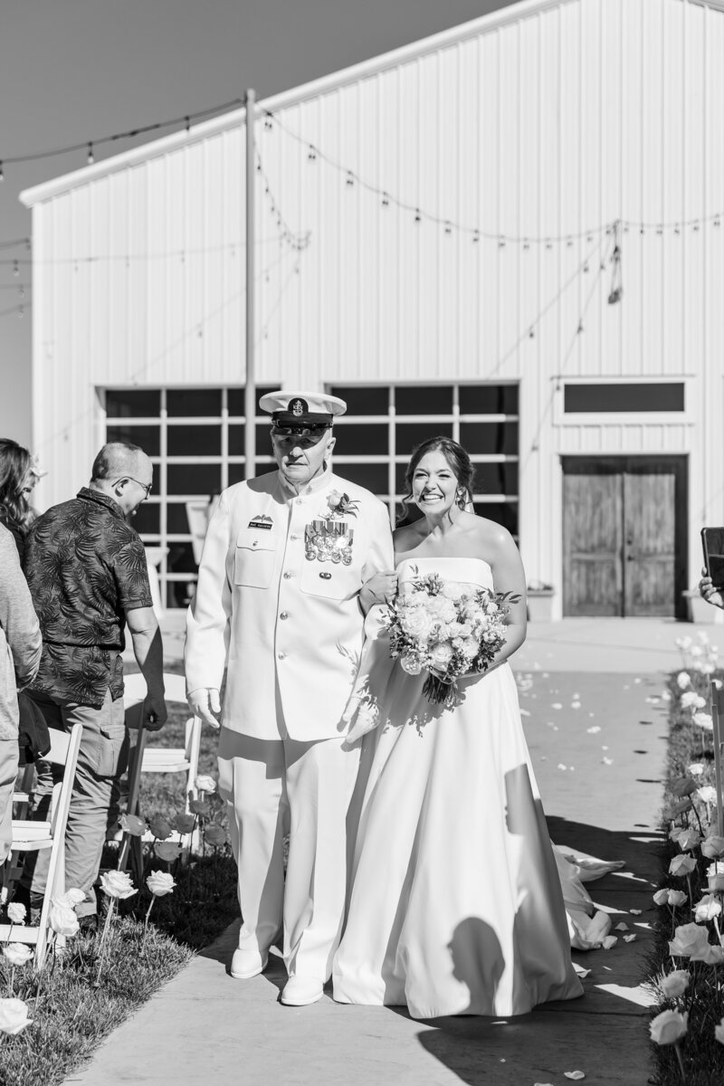 a man in a military uniform walking a bride down the aisle