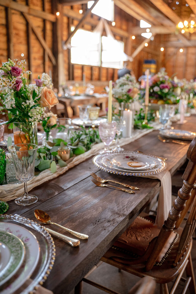 wedding table centerpiece with flowers, candles, and greenery