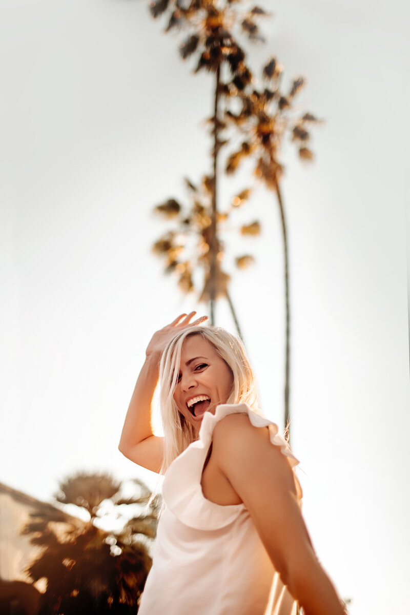 Christine Dammann shows her silly personality while she poses with palm trees behind her- she is obsessed with palm trees