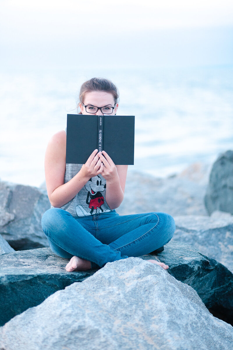 Senior girl at the beach with her book