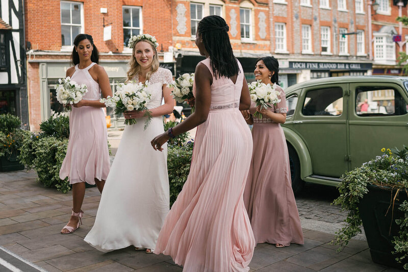 A bride arriving at her wedding ceremony with her bridesmaids