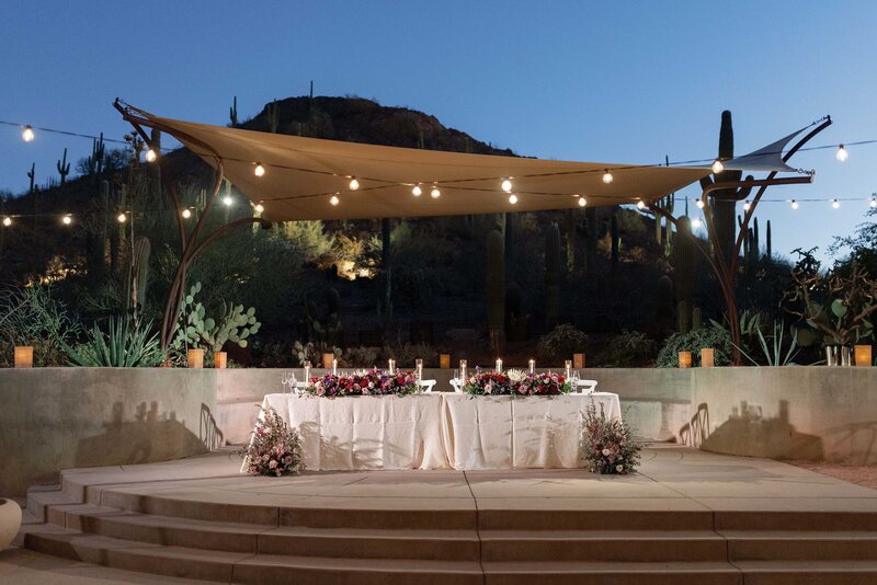 Sweetheart table at wedding reception with twinkle lights.
