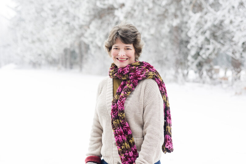 Tammy outside in the snow wearing a scarf smiling