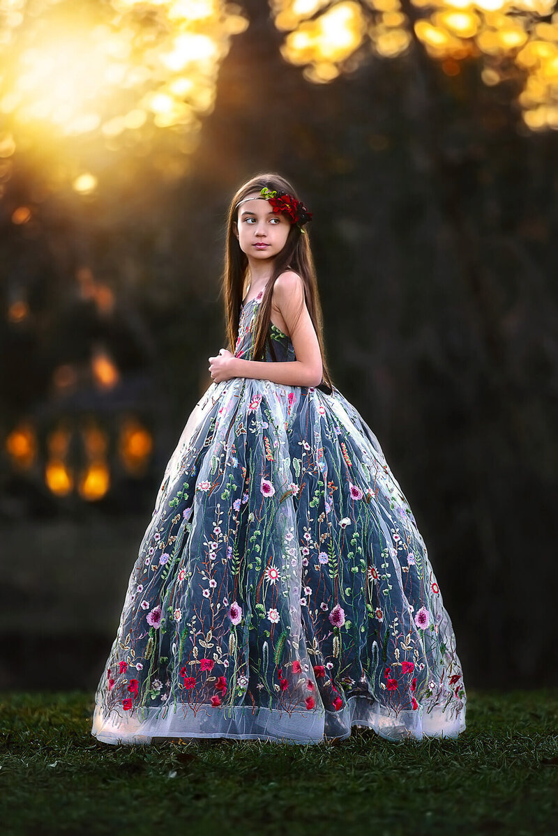 Gorgeous tween wearing couture dress with golden light in the background
