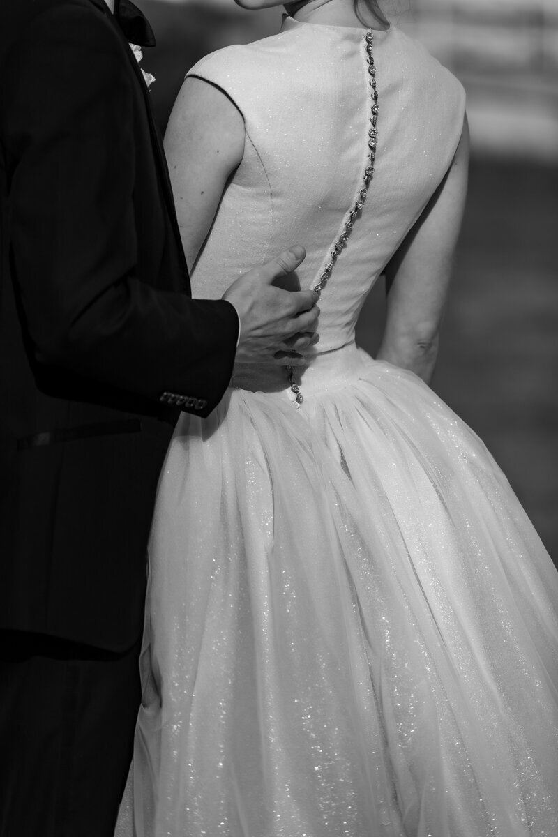 groom in white tuxedo kisses brides shoulder during speeches at Toronto bar wedding