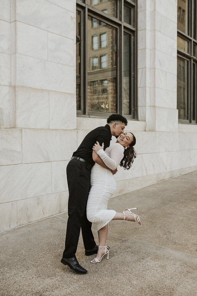a man dipping his fiance and kissing her on the cheek