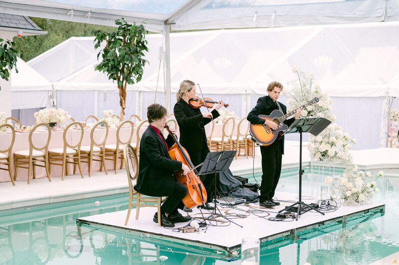 wide shot of black and white wedding reception with white chairs and white florals
