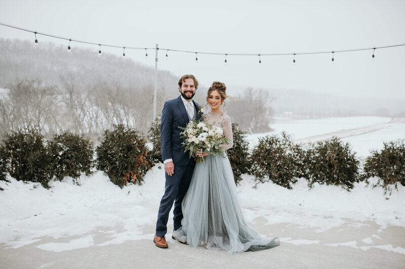 Bride and groom embracing in snowy landscape at a luxury winter wedding in Minnesota