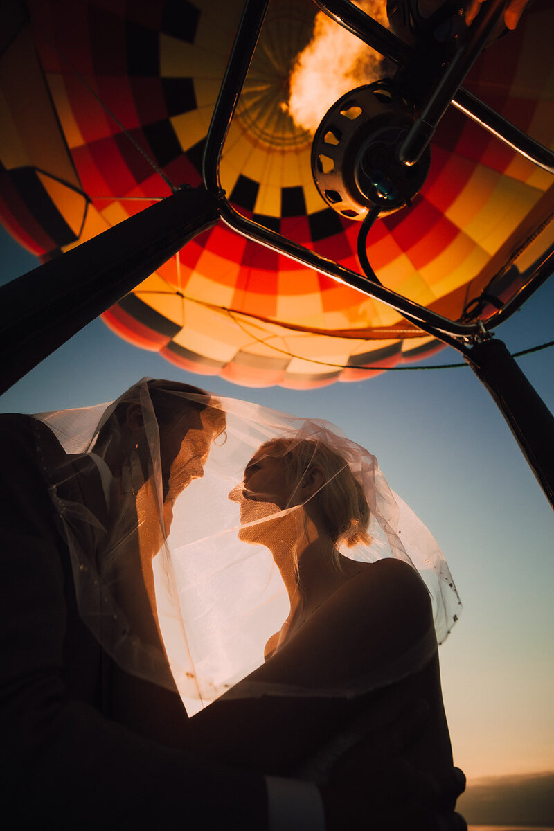 Bride and groom gaze at each other under the brides veil during their Stillwater hot air balloon elopement