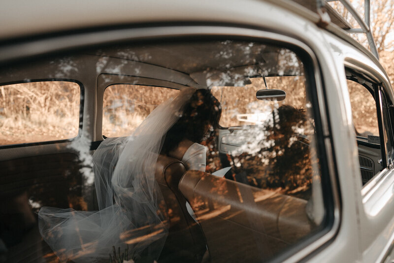 couple in a white VW wedding car heading toward their Church Hill reception