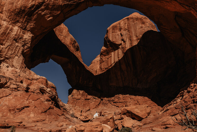 Bride and groom stand in Double Arch in Arches National Park for Elopement