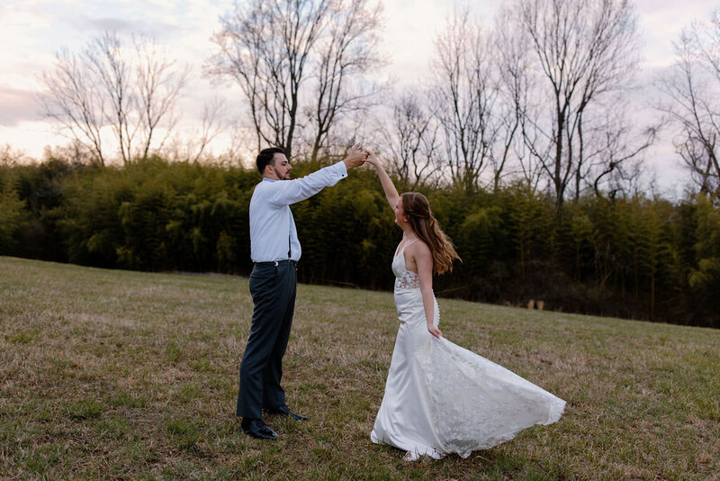 Bride and groom spinning together outdoors in their wedding attire during a joyful moment in New York City