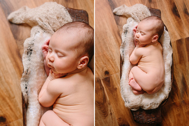 A newborn baby sleeping in a wooden dough bowl