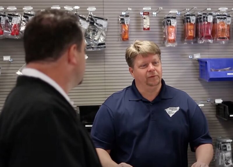 A person talking to a worker behind the counter at a store 