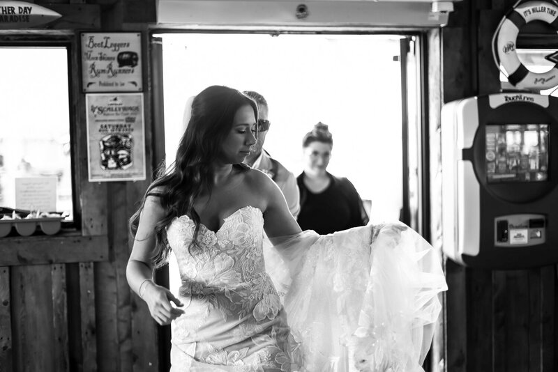 Bride walking into Rum Runners with train thrown over her forearm