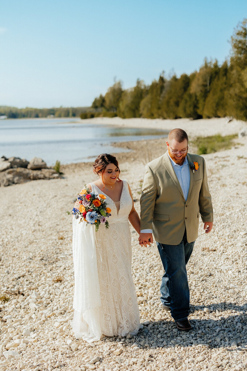 couple running on the beach at their Lake Michigan engagement photoshoot