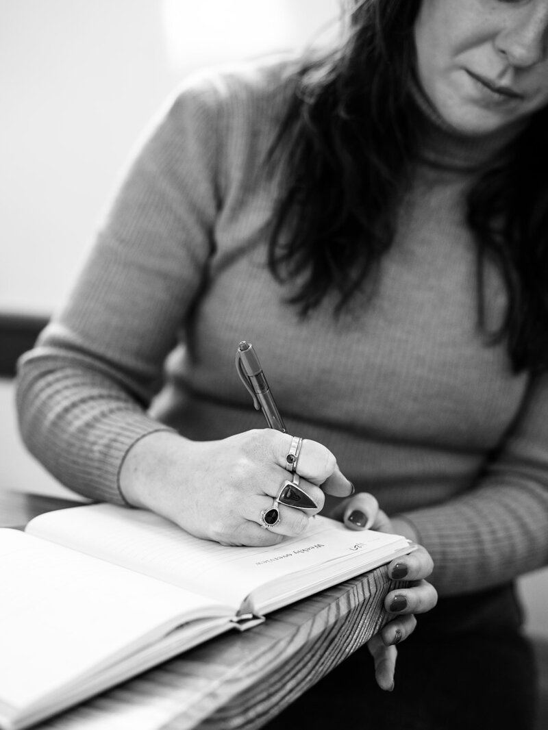 Up close of Bloem Creations holding a pen and writing, representing copywriting services offered to clients. 