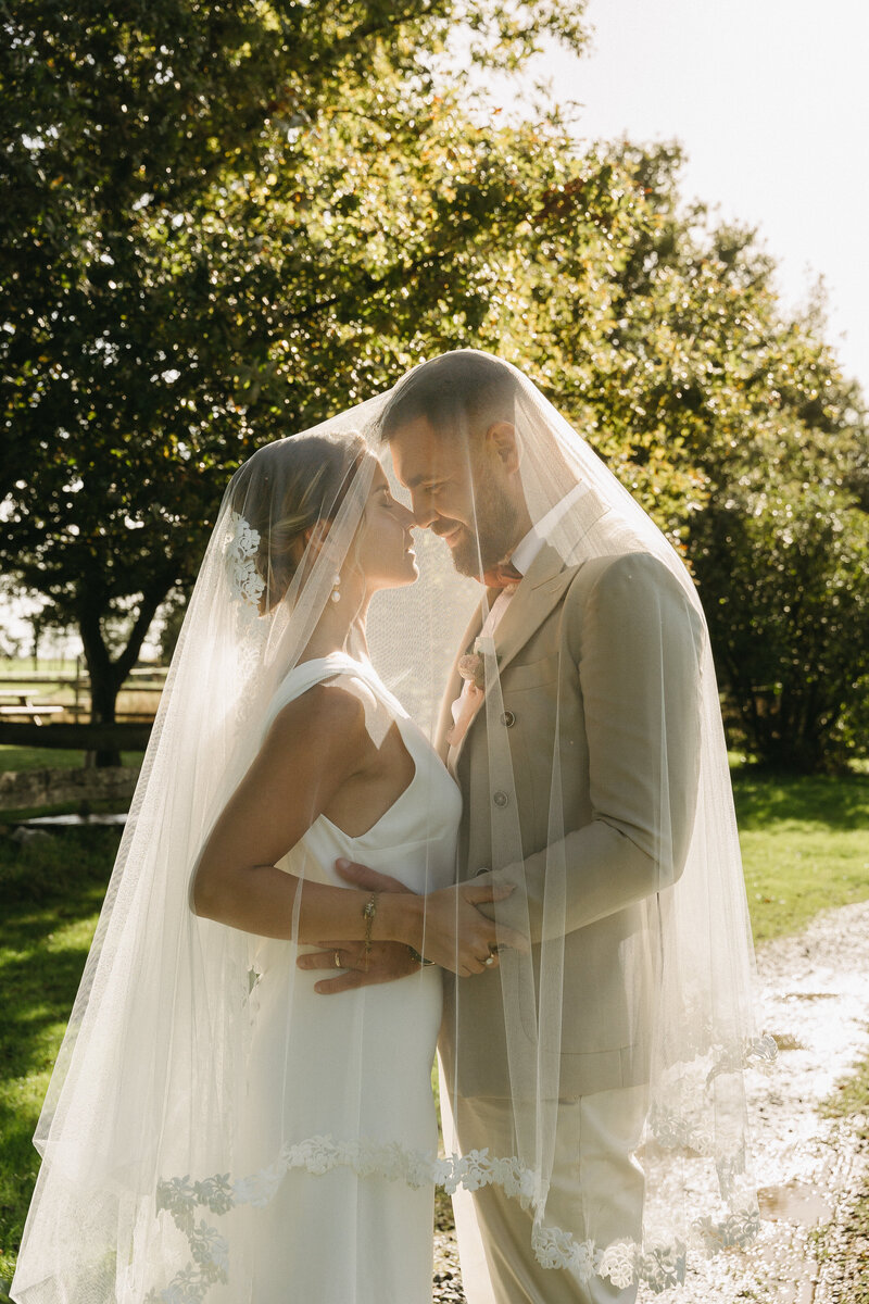 Mariés l'un contre l'autre recouverts d'un voile. Scène de mariage imaginée par Nos moments ensemble, wedding planner nantes Loire Atlantique vendée