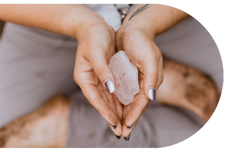 Closeup of woman's hands holding  freeform crystal quartz.