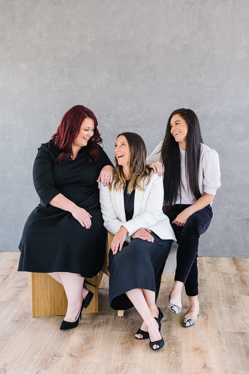 Anna Delores founder, Emily, smiles and laughs with 2 female photography students