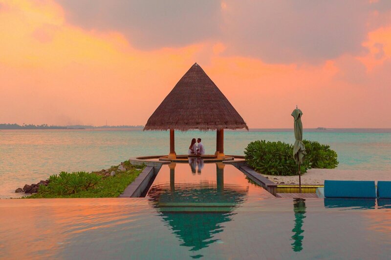 couple sitting under a hut covering planned with travel concierge services, GG Mack