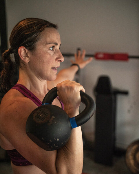 Vanessa Flores performing a kettlebell press during strength training for midlife women.