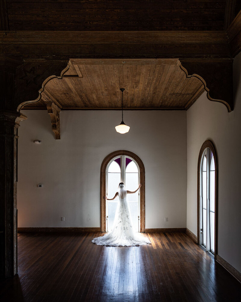 Bride in front of window at Livaudais Hall wedding venue