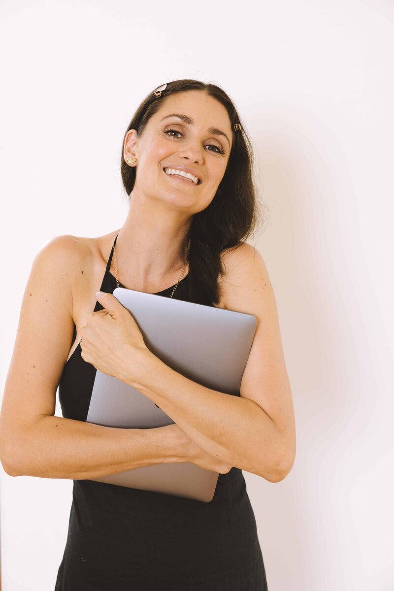 Marisa Twentyman copywriter smiling holding course template laptop