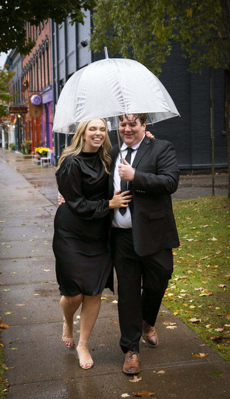 Photo of an engaged couple walking downtown