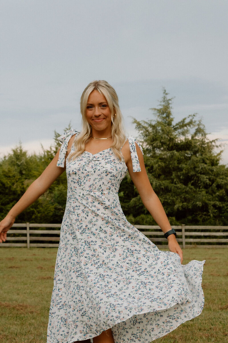 girl poses for senior photos in dress