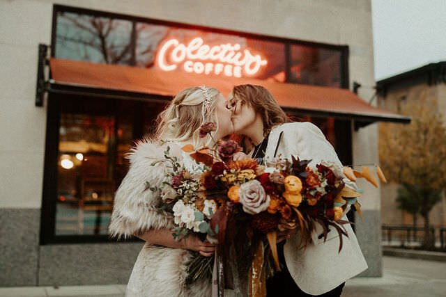 couple kissing holding bouquet of flowers