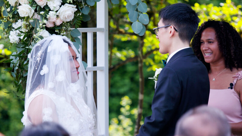 bride and groom smiling at each other while holding hands