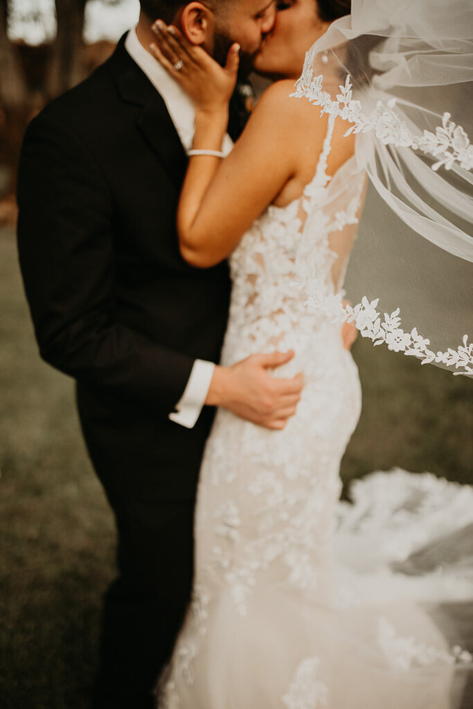Close-up and slightly blurred shot capturing the groom embracing the bride – a moment of pure intimacy and love.