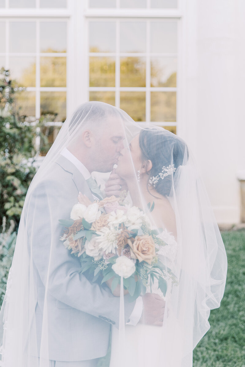 Couple sharing a moment under veil at Raspberry Plains Manor