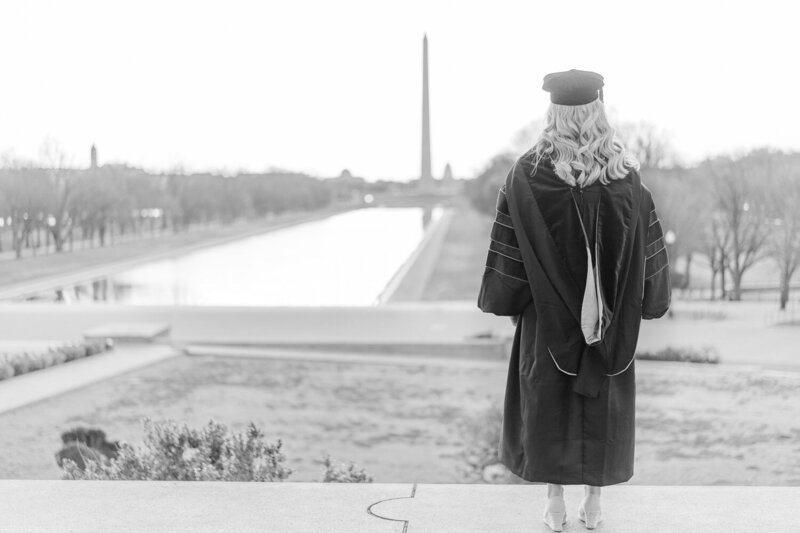 college girl wearing graduation cap & gown looking away during Washington, DC senior pictures