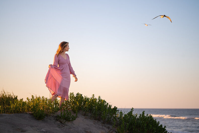 Portrait of a lady in a pink dress watching the ocean in Outer Banks