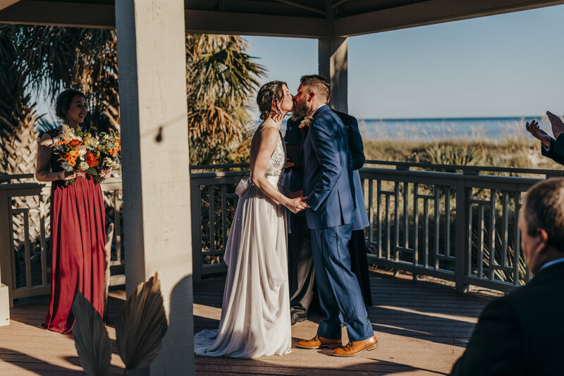 Bride and groom kissing at shipyard beach club wedding ceremony
