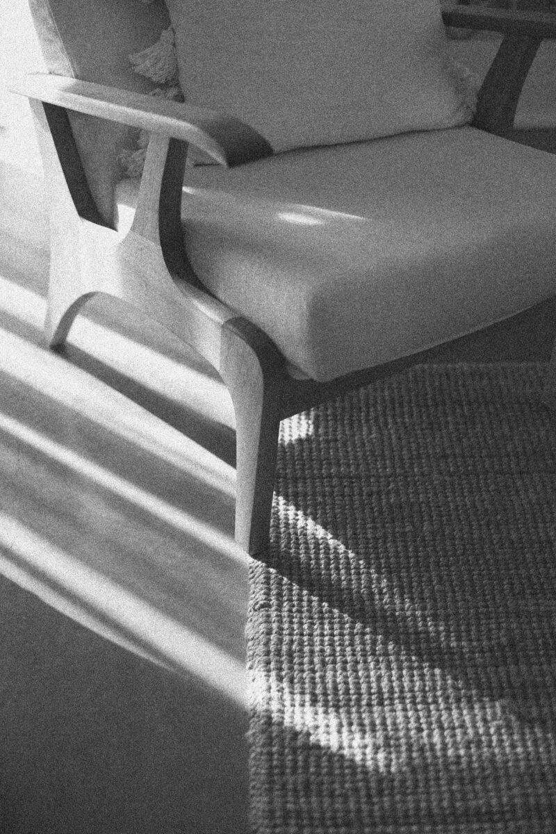 Black-and-white photo of a sunlit therapy chair and woven rug, symbolizing safety, containment, and clarity in trauma-informed EMDR and IFS therapy with Jessie Withers in Los Angeles, CA