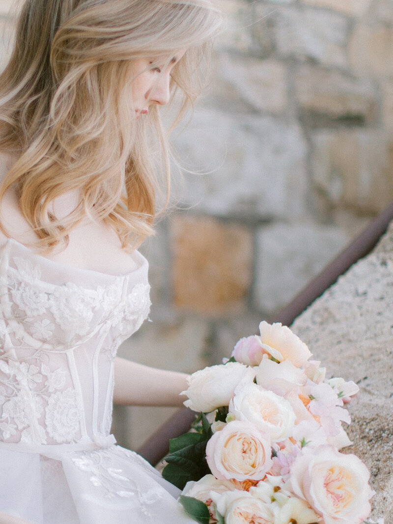 FAQ, image of a bride looking at her beautiful bouquet at Sunstone Winery