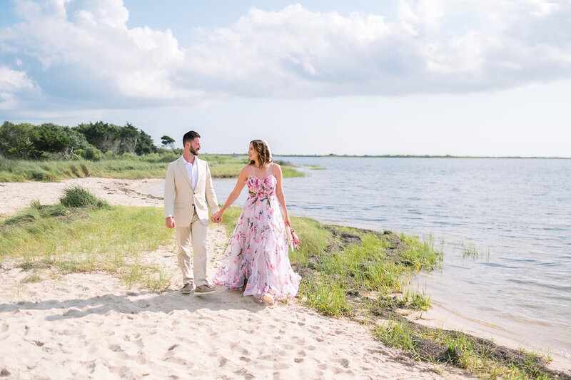 wedding couple laughing holding hands in greenery