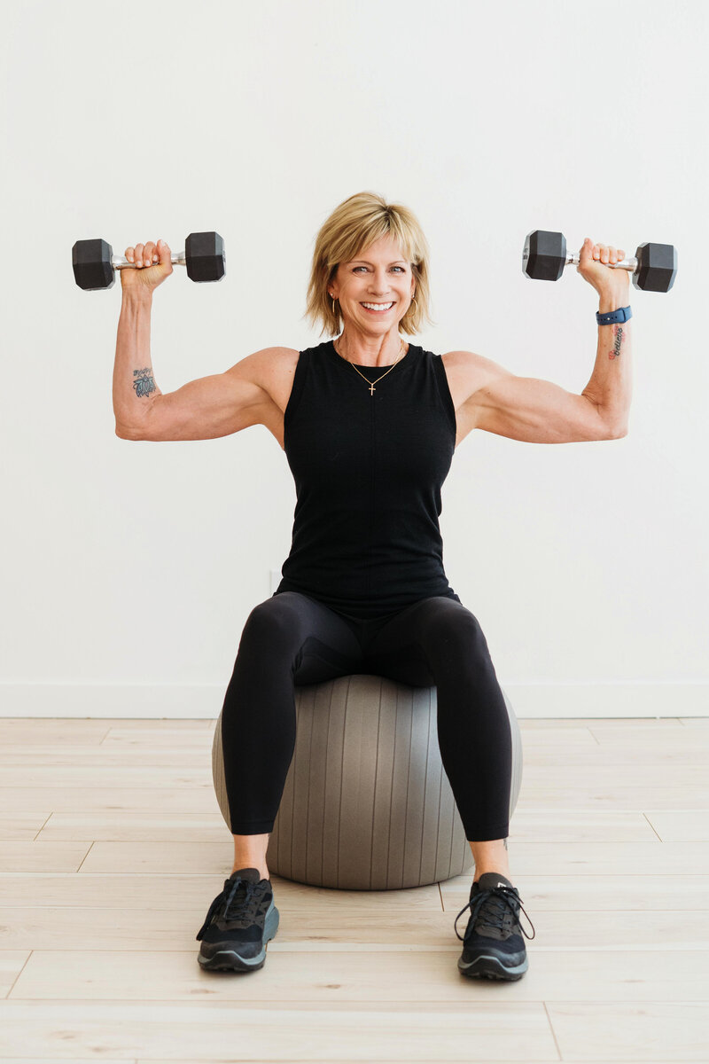 Sue Karthaiser on a yoga ball with dumbells