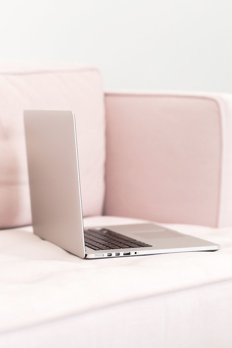 Open laptop on pink couch