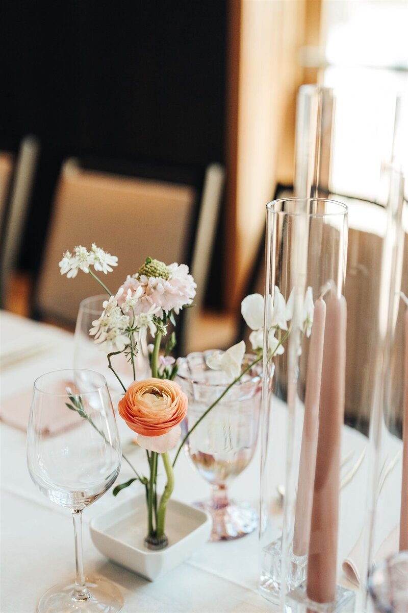 Peach ranunculus, blush scabiosa, white sweet peas and orlaya in pin frog on guest table at Black Butte Ranch