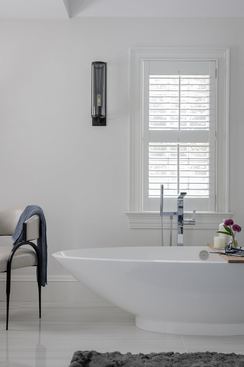 Modern bathroom designed by Boston interior designer, featuring a freestanding soaking tub and minimalist finishes