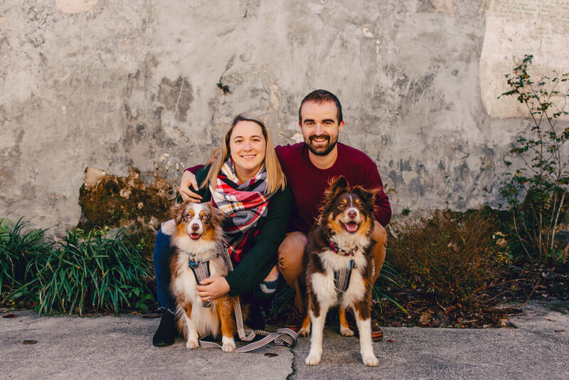 couple with their two australian shepherds