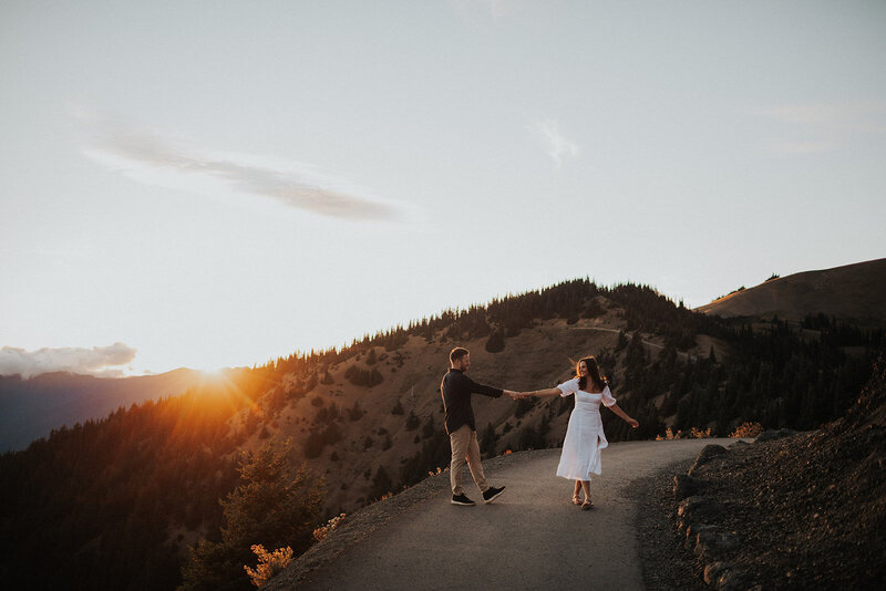 couple holding hands walking down path